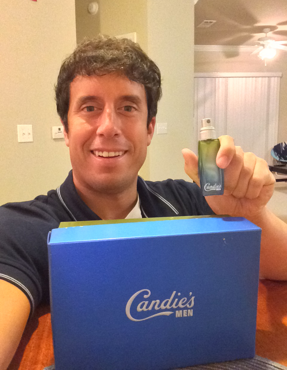 Here I am holding a nearly empty bottle of my cologne while sitting behind one of the boxes that was shipped to me.